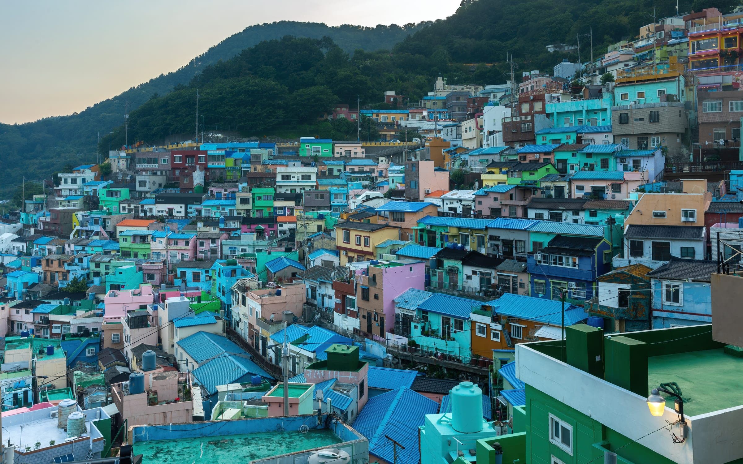Pastel houses stacked up the hillside of Gamcheon Culture Village at sunset