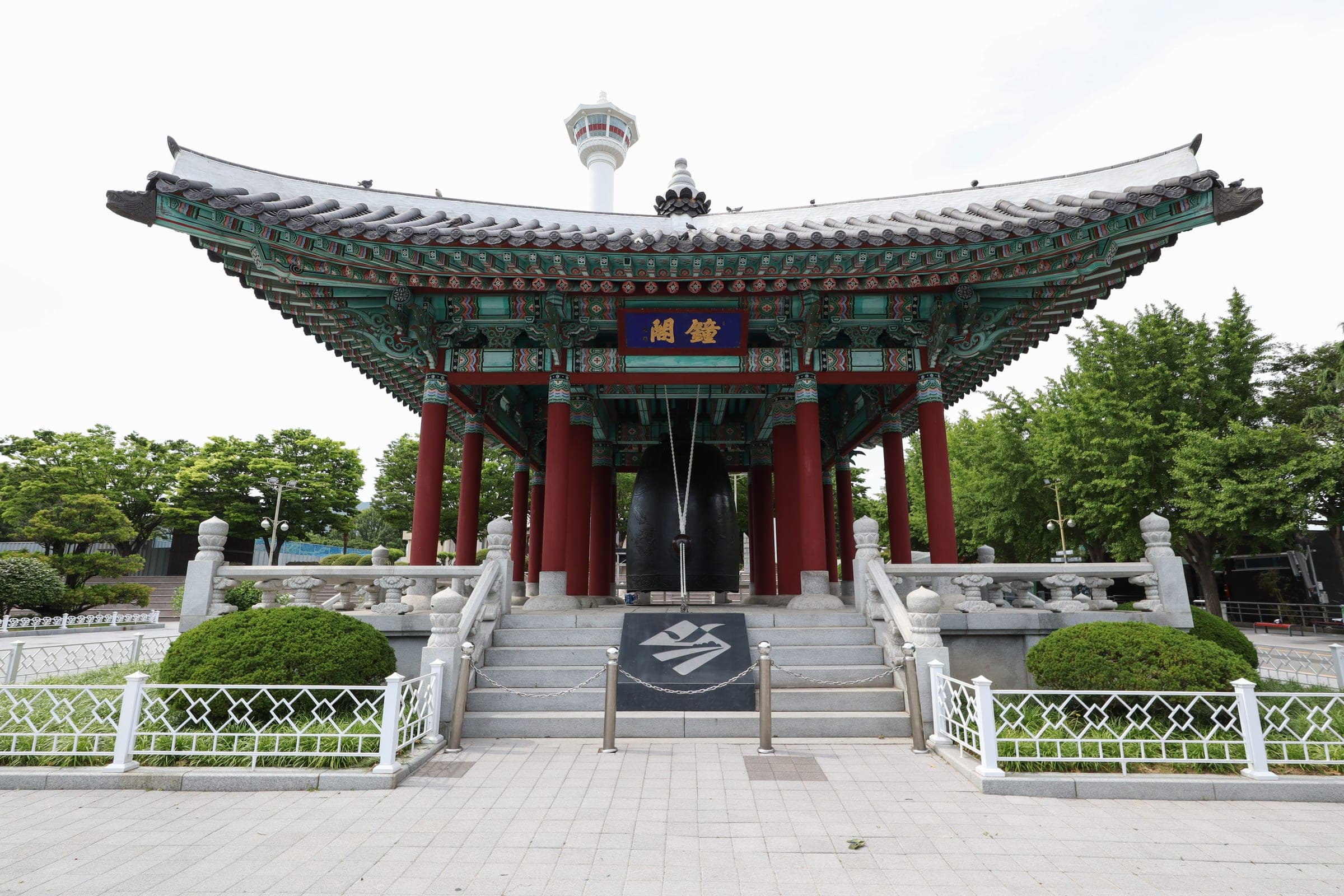 Busan Tower rising behind the bell pavilion in Yongdusan Park