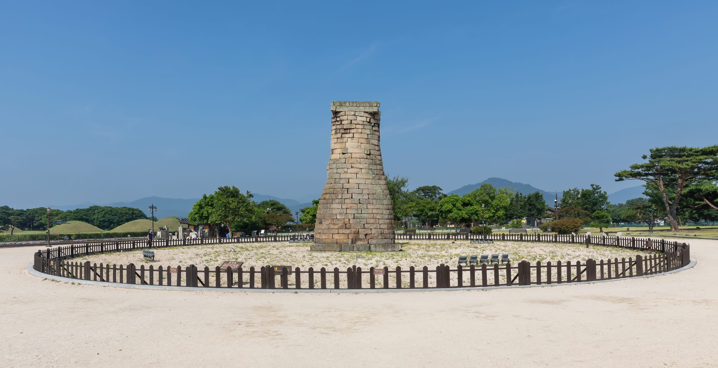 The stone bottle-shaped Cheomseongdae observatory on a lawn under a blue sky in Gyeongju