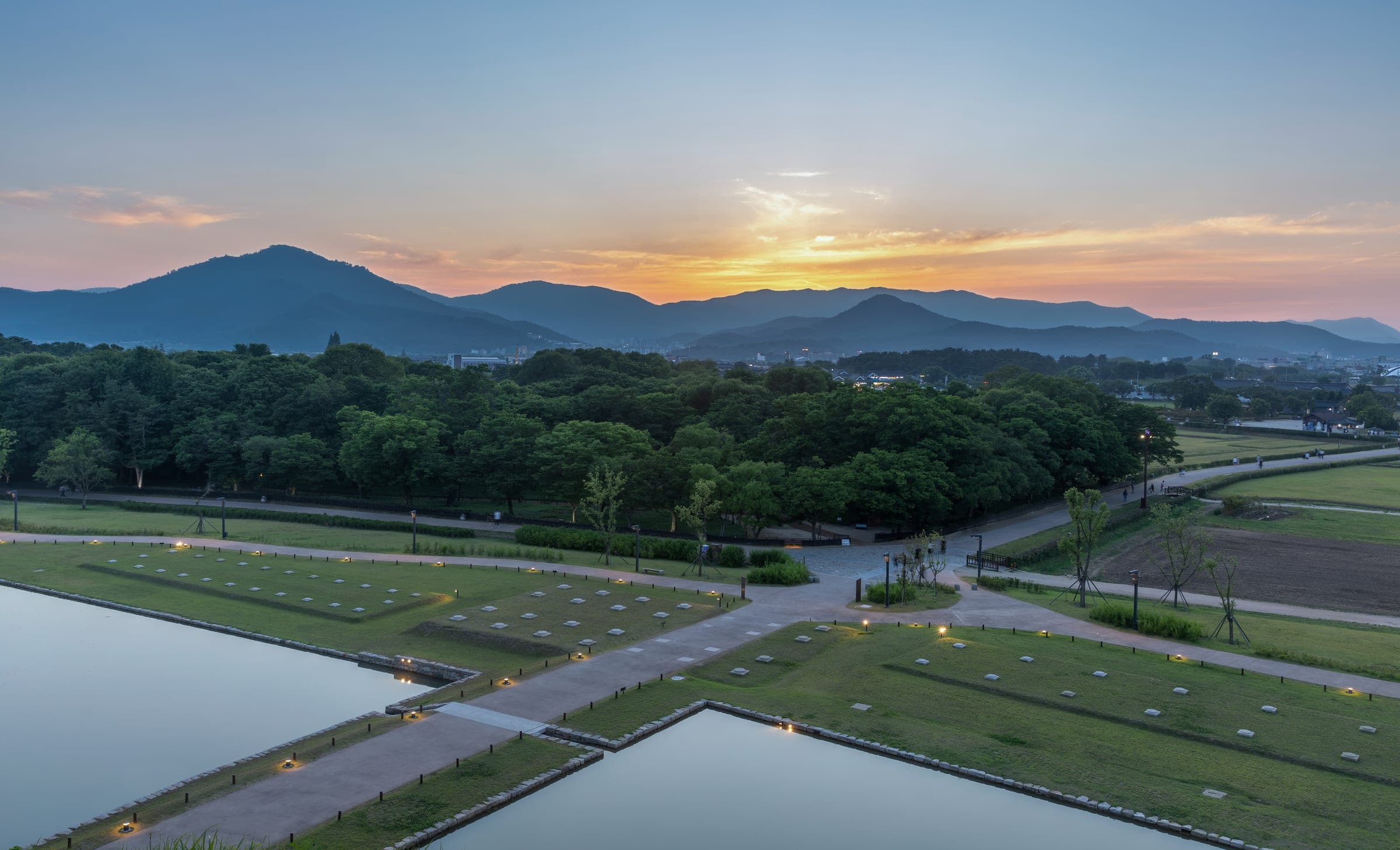 Grass-covered royal burial mounds catching the sunset in Gyeongju