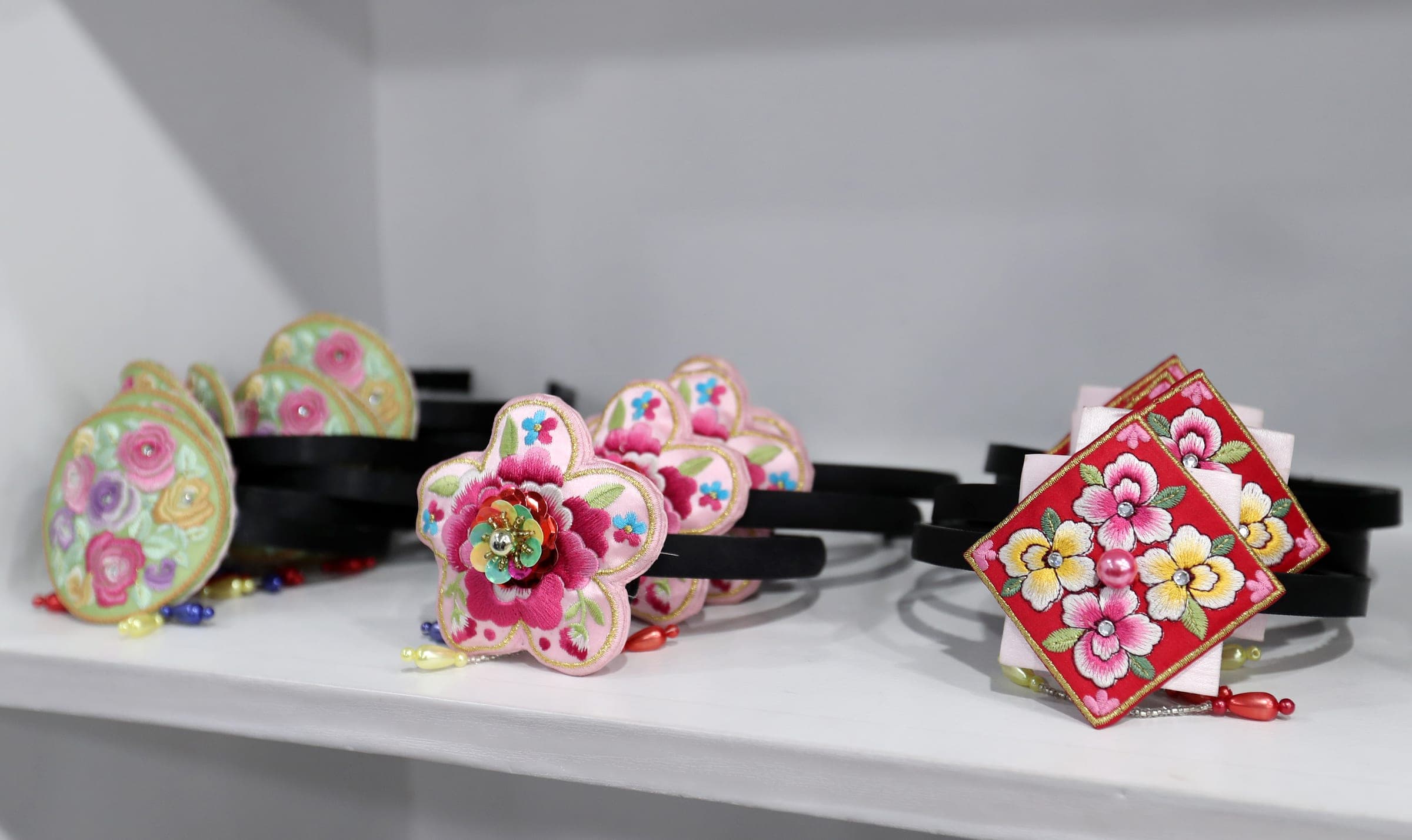 Embroidered floral hair accessories for hanbok displayed on a shelf