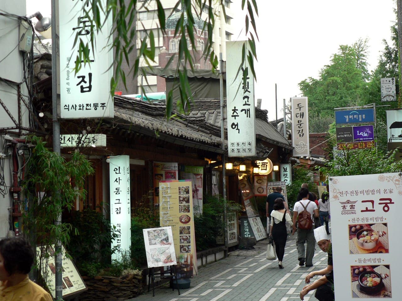 Hanok restaurants with vertical signboards along a narrow lane in Insadong