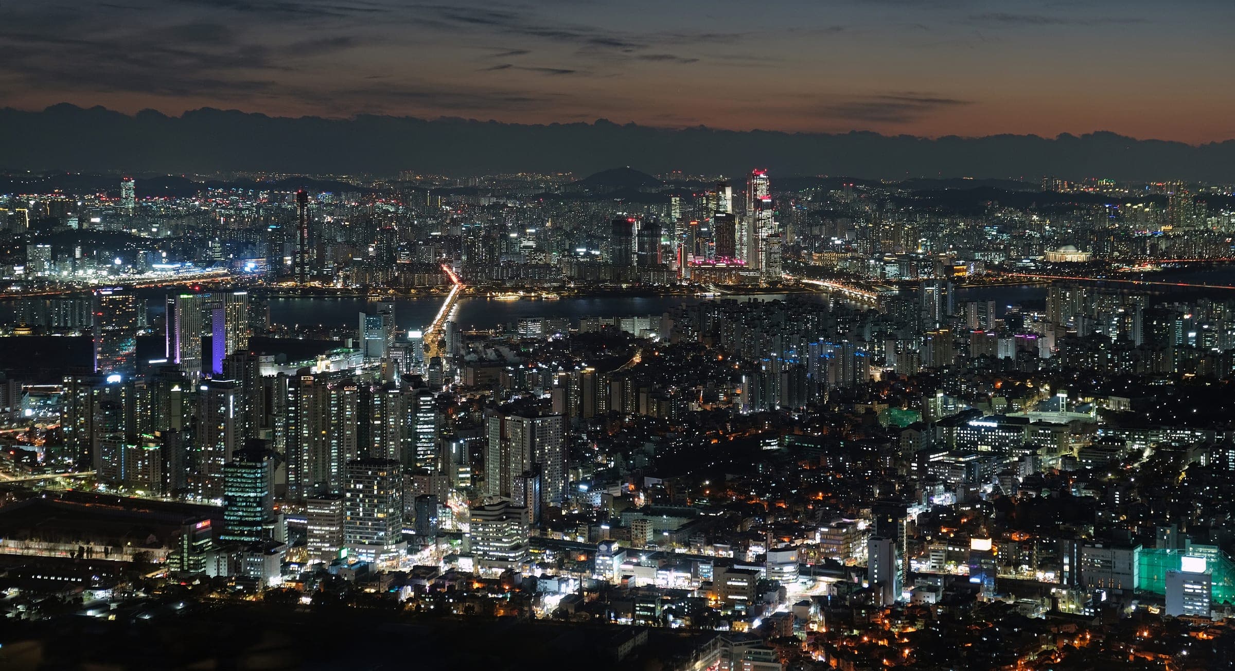 N Seoul Tower rising above the wooded slopes of Namsan with the city beyond