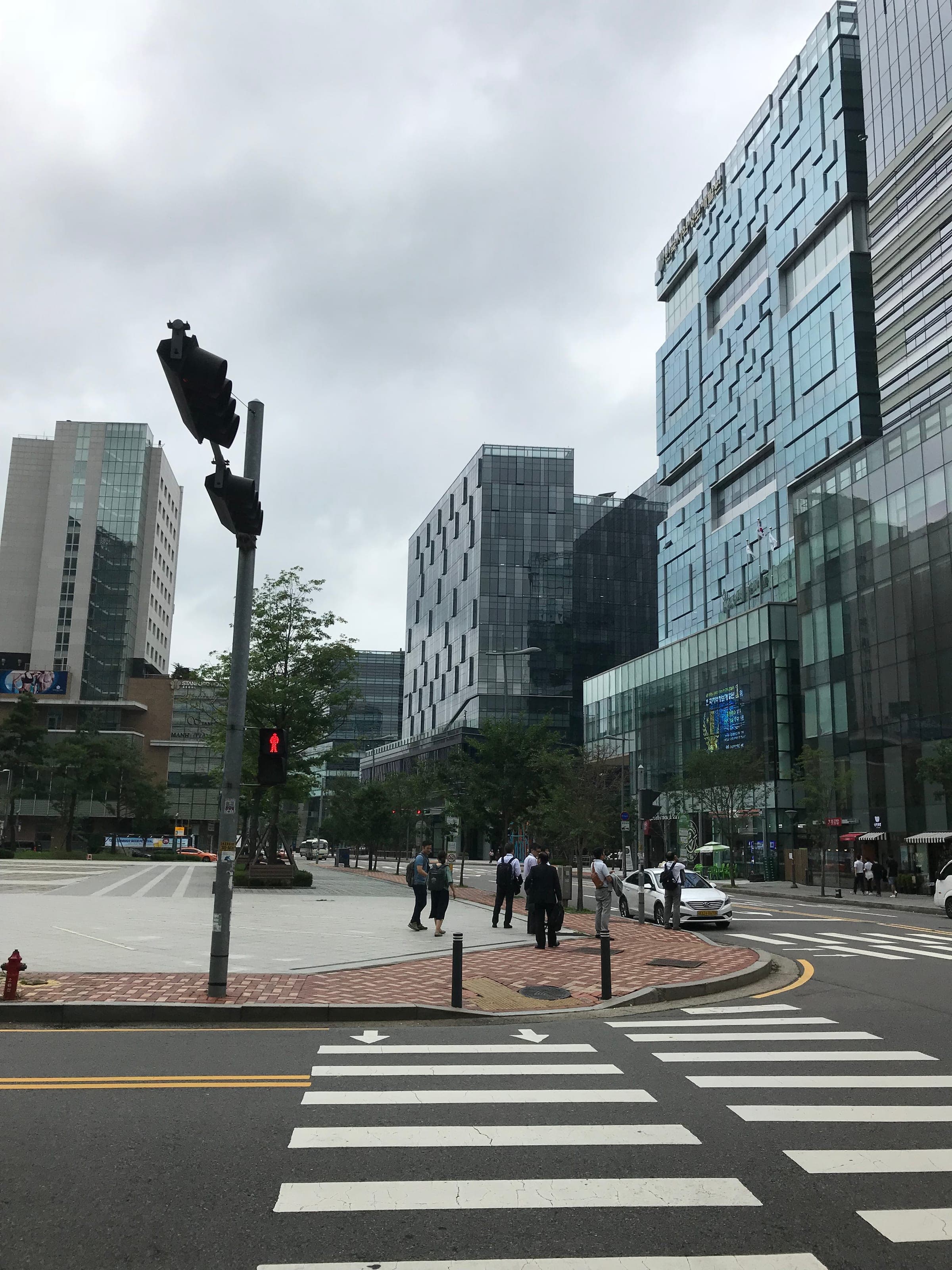 Glass office towers and a wide crossing in Digital Media City, Sangam-dong, on a cloudy day