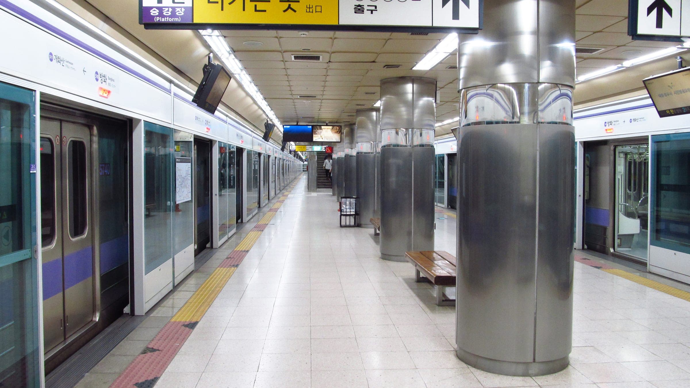 A Seoul Metro platform with platform screen doors and a waiting train